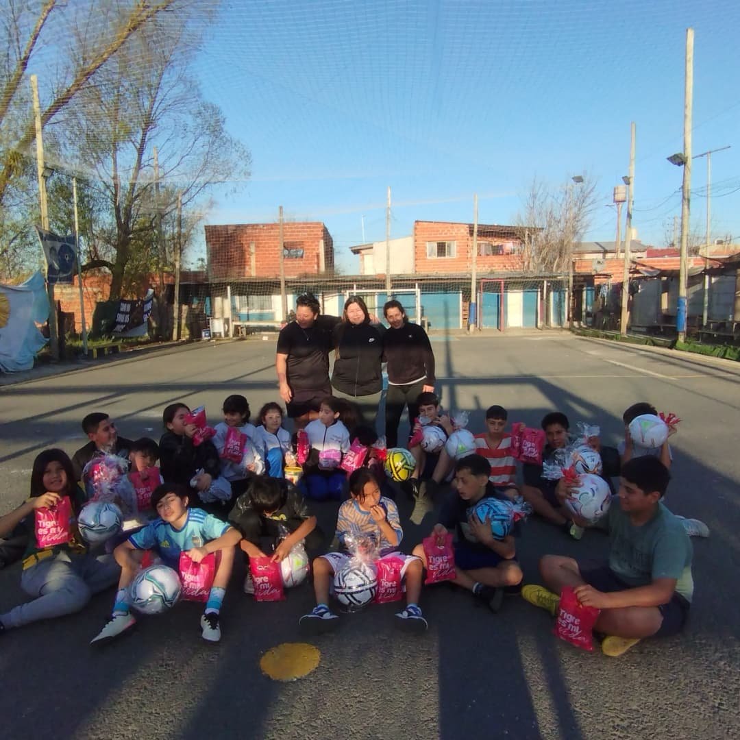 Grupo de chicos y chicas del barrio después de entrenar en la canchita