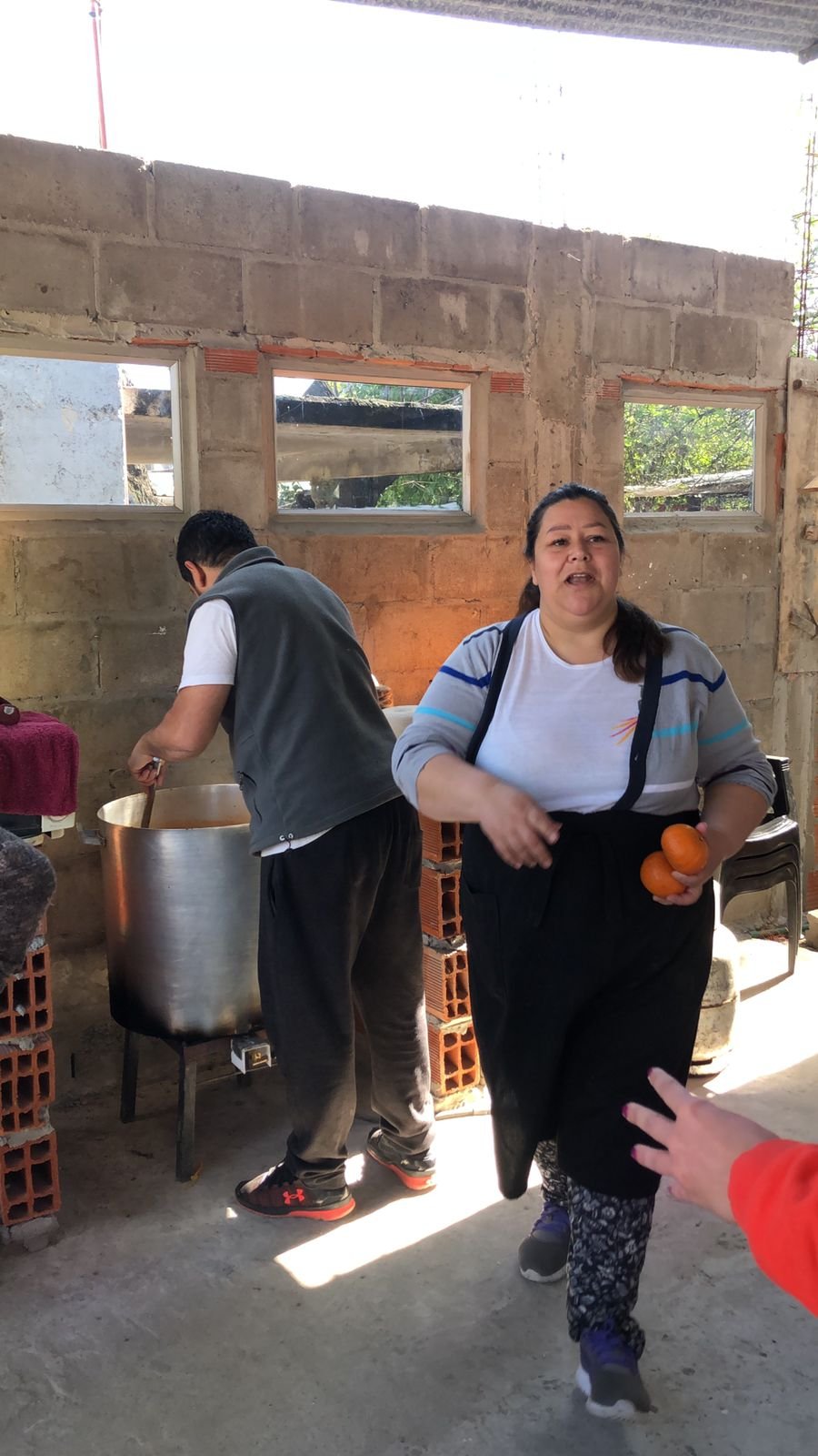 Gisele en el espacio semicubierto de la cocina, aún en construcción